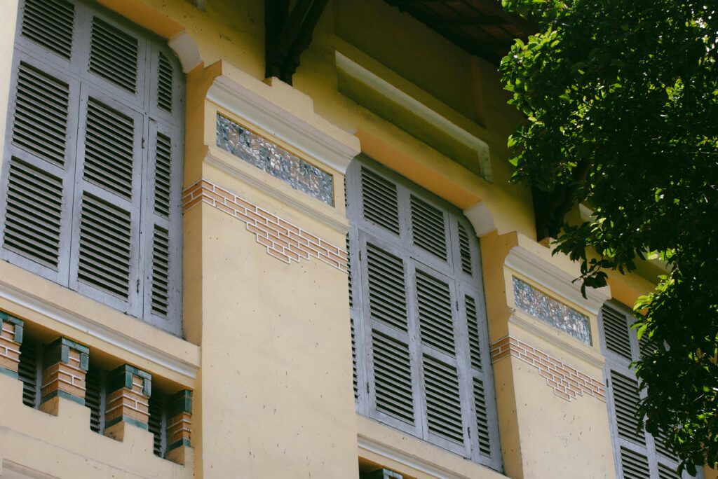 Close-up of colonial-style windows and architecture in Ho Chi Minh City, Vietnam.